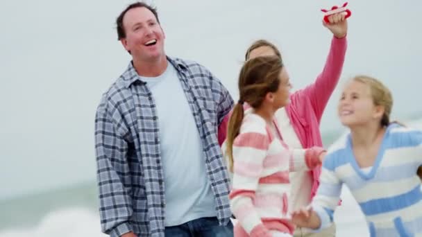 Rodina se baví s drakem na pláži — Stock video