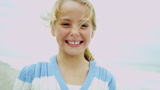 Chica en la playa sonriendo a la cámara — Vídeo de stock