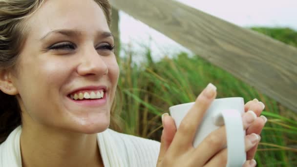 Flicka på stranden dricka kaffe — Stockvideo