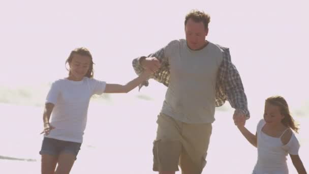 Vater mit Töchtern spielt am Strand — Stockvideo