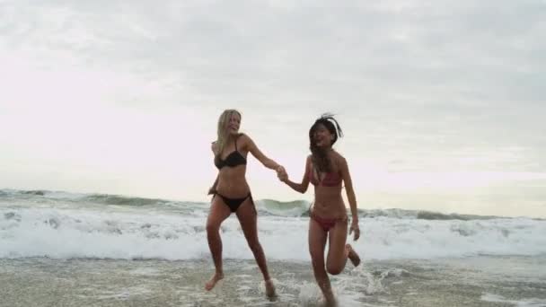 Meninas vestindo biquíni correndo na praia — Vídeo de Stock