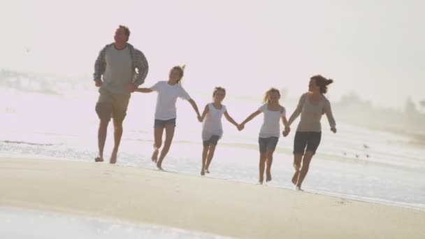 Familjen kör tillsammans på stranden — Stockvideo