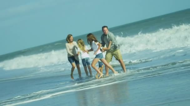 Родители с дочерьми играют на пляже — стоковое видео