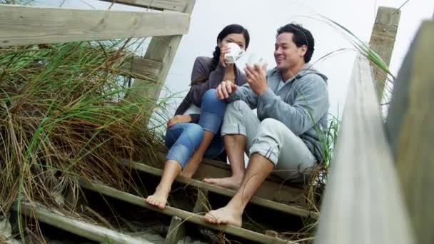 Пара на пляже пьет кофе — стоковое видео