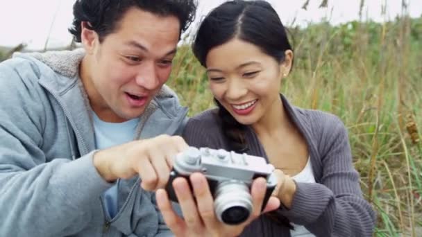 Пара на пляжі у відпустці за допомогою камери — стокове відео