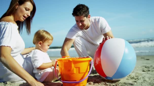 Eltern mit Sohn spielen am Sandstrand — Stockvideo