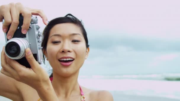 Girl taking photograph on beach — Stock Video