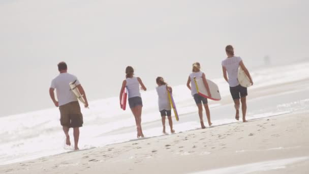 Сім'я, що біжить з дошками для тіла на пляжі — стокове відео