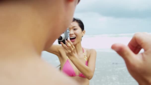 Pareja en la playa usando la cámara — Vídeos de Stock