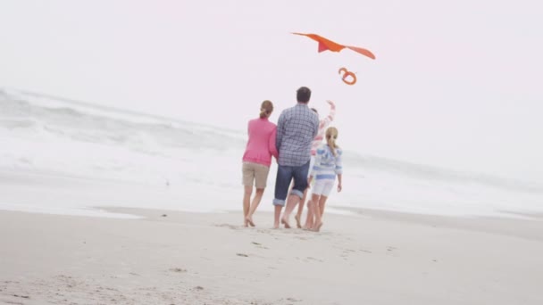 Rodina se baví s drakem na pláži — Stock video