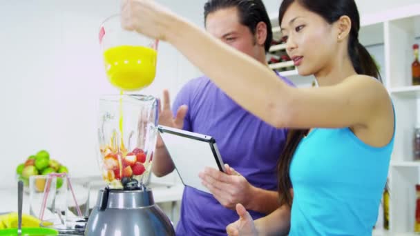 Pareja haciendo delicioso batido de frutas orgánicas — Vídeo de stock