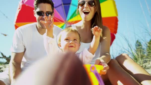 Parents with baby playing in sand — Stock Video