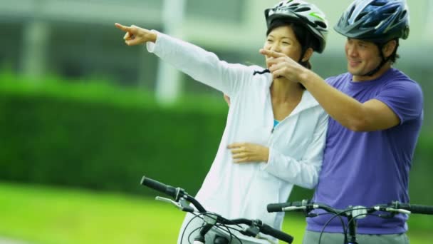 Pareja montando sus bicicletas al aire libre — Vídeos de Stock