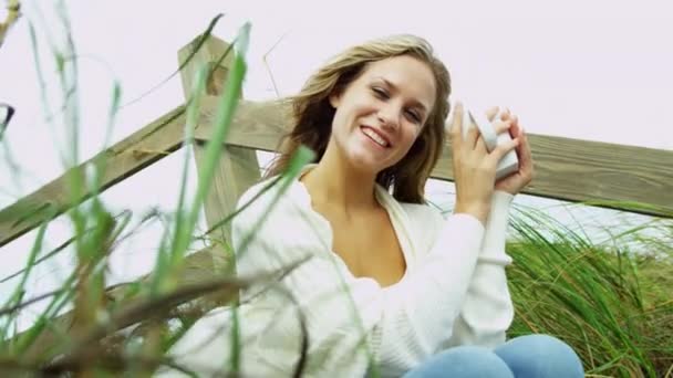 Girl on beach drinking coffee — Stock Video