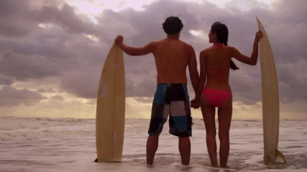 Par med surfbrädor på stranden — Stockvideo