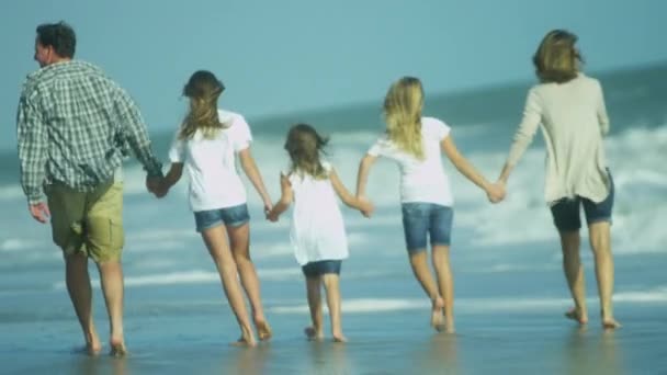 Padres con hijas caminando en la playa — Vídeo de stock