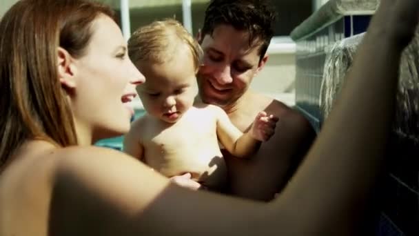 父母抱着婴儿游泳池 — 图库视频影像