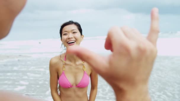 Pareja en la playa usando la cámara — Vídeos de Stock