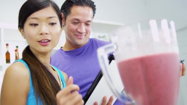 Pareja haciendo delicioso batido de frutas orgánicas — Vídeos de Stock