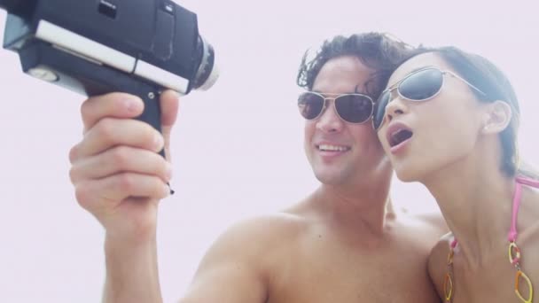Pareja en la playa con cámara de vídeo — Vídeos de Stock