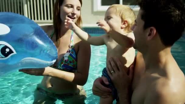 Padres jugando con su hijo en la piscina — Vídeo de stock