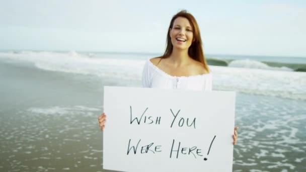 Frau am Strand mit Hinweistafel — Stockvideo