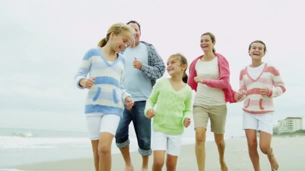 Familie lopende blootsvoets langs strand — Stockvideo