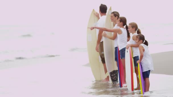 Ouders en dochters kijken naar golven op het strand — Stockvideo