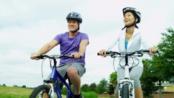 Pareja montando sus bicicletas al aire libre — Vídeo de stock