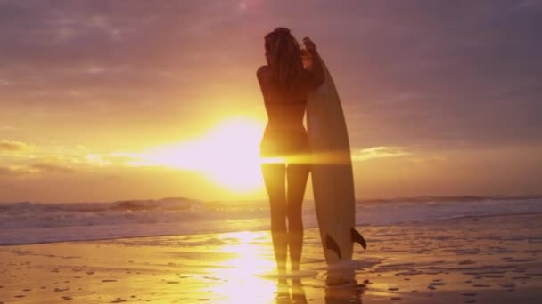 Vrouw op het strand bij zonsondergang — Stockvideo