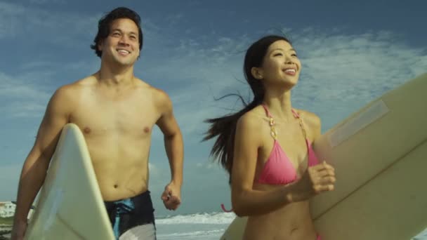 Surfování pár běží vedle oceánu — Stock video