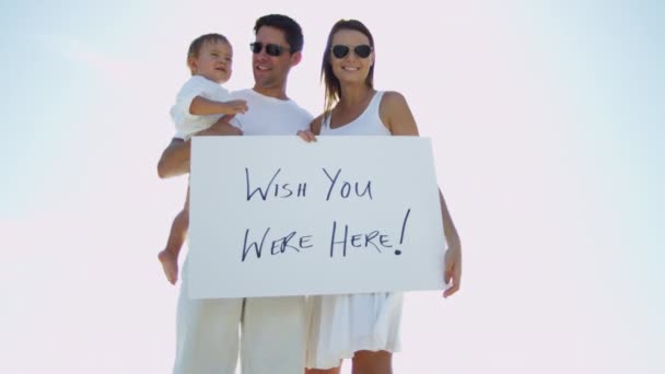 Famille sur la plage tenant le panneau de message — Video