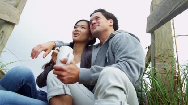 Pareja en la playa bebiendo café — Vídeos de Stock