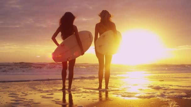 Niñas sosteniendo tablas de surf en la playa — Vídeo de stock