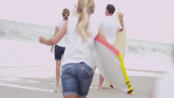 Girls running to parents watching waves — Stock Video