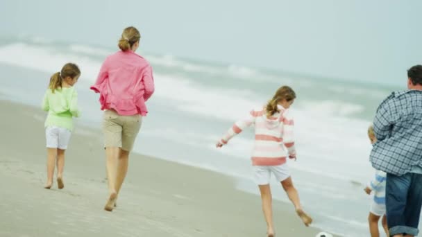 Familia caucásica disfrutando del tiempo en la playa — Vídeo de stock