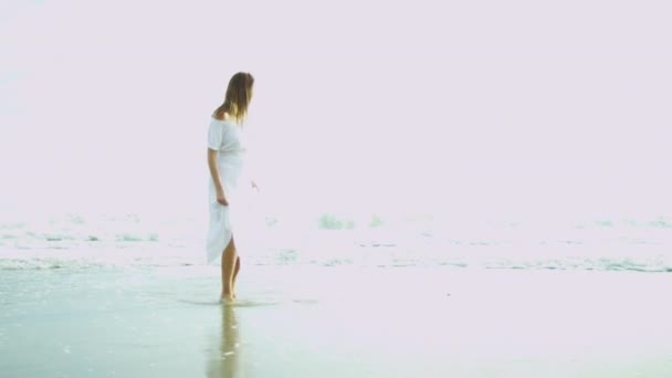 Mulher de vestido branco ao lado do oceano — Vídeo de Stock