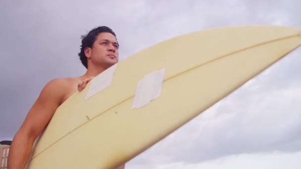 Hombre con tabla de surf viendo olas — Vídeos de Stock