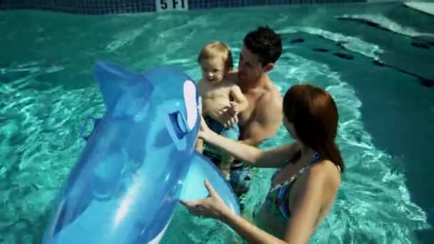 Padres jugando con su hijo en la piscina — Vídeo de stock