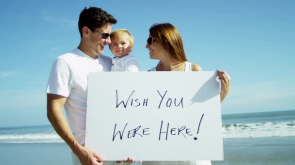 Сім'я на пляжі тримає дошку оголошень — стокове відео