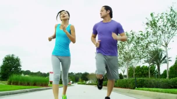Paar in sportkleding joggen in het park — Stockvideo