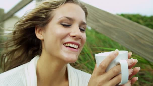 Chica en la playa bebiendo café — Vídeo de stock