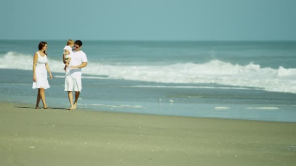 Батьки з дитиною насолоджуються пляжним відпочинком — стокове відео