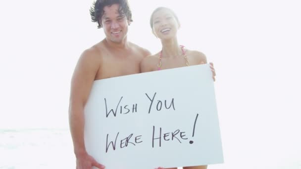 Couple on beach with white board — Stock Video