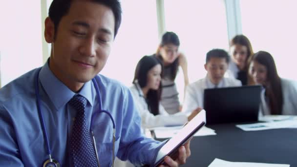 Aziatische medische leidinggevenden in ziekenhuis boardroom — Stockvideo