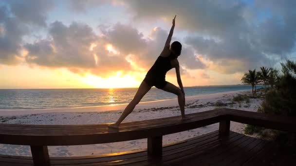 Young woman doing yoga on a beach — Stock Video