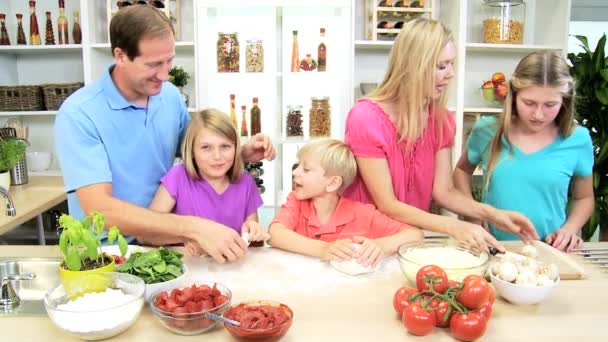 Родители и дети вместе готовят пиццу — стоковое видео