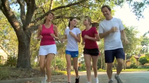 Parents with young teenage daughters jogging — Stock Video