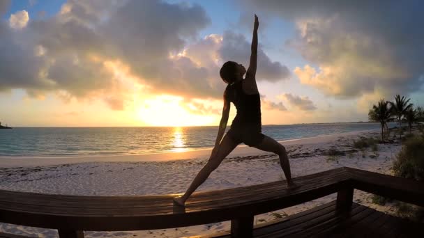 Jonge vrouw doet yoga op een strand — Stockvideo