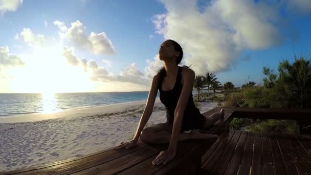 Jonge vrouw doet yoga op een strand — Stockvideo